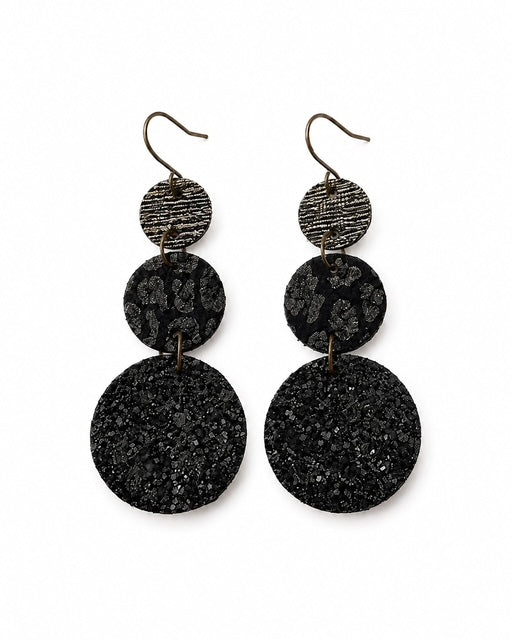 Black leather circle earrings on a white background with graduated textured circles