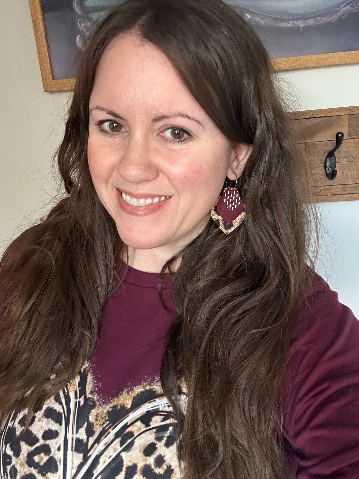 Model wearing small layered maroon suede and leopard leather hoop earrings with antique bronze
 hoops