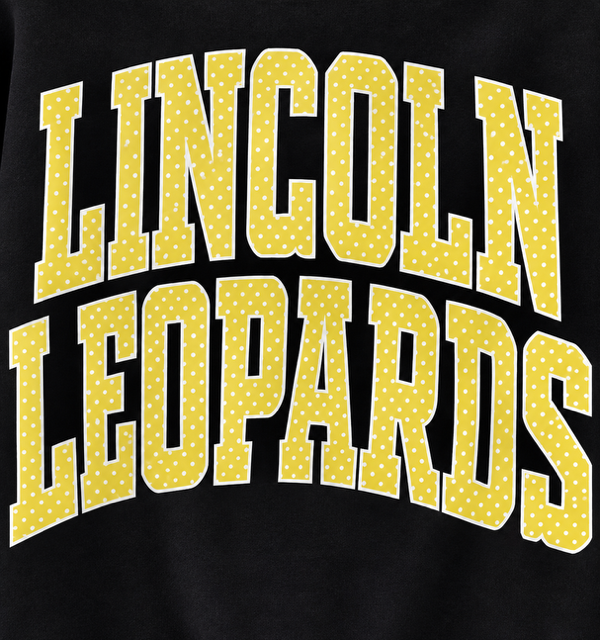 Close-up of yellow polka-dot Lincoln Leopards lettering with a white outline
