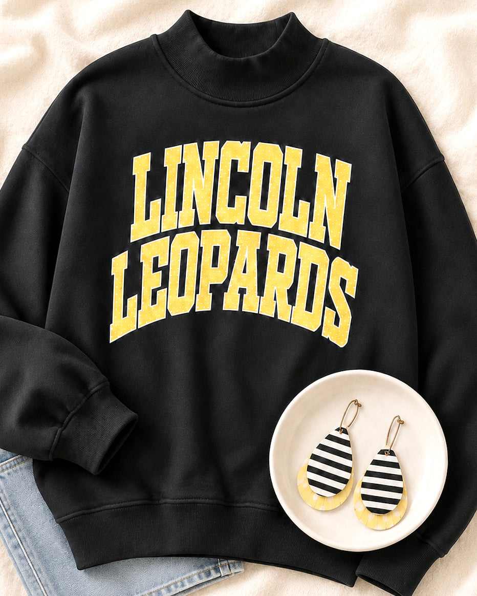 Leopard Legacy Mockneck styled with coordinating striped, yellow, and leopard earrings
