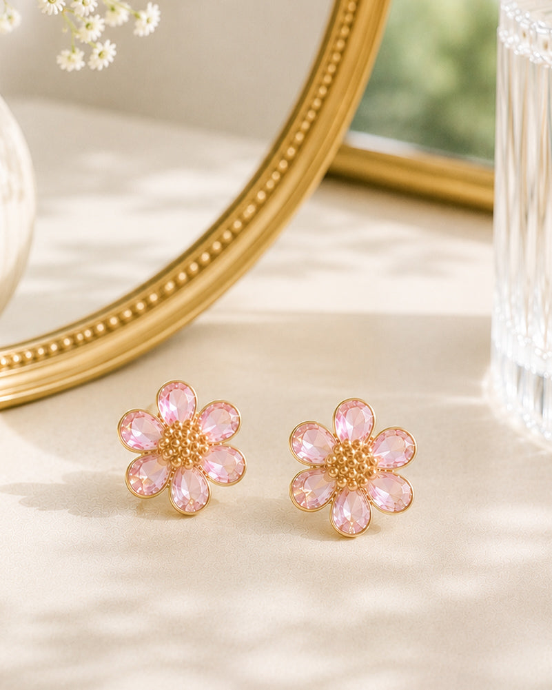 Morning Bloom blush pink flower stud earrings styled on a vanity with a gold mirror