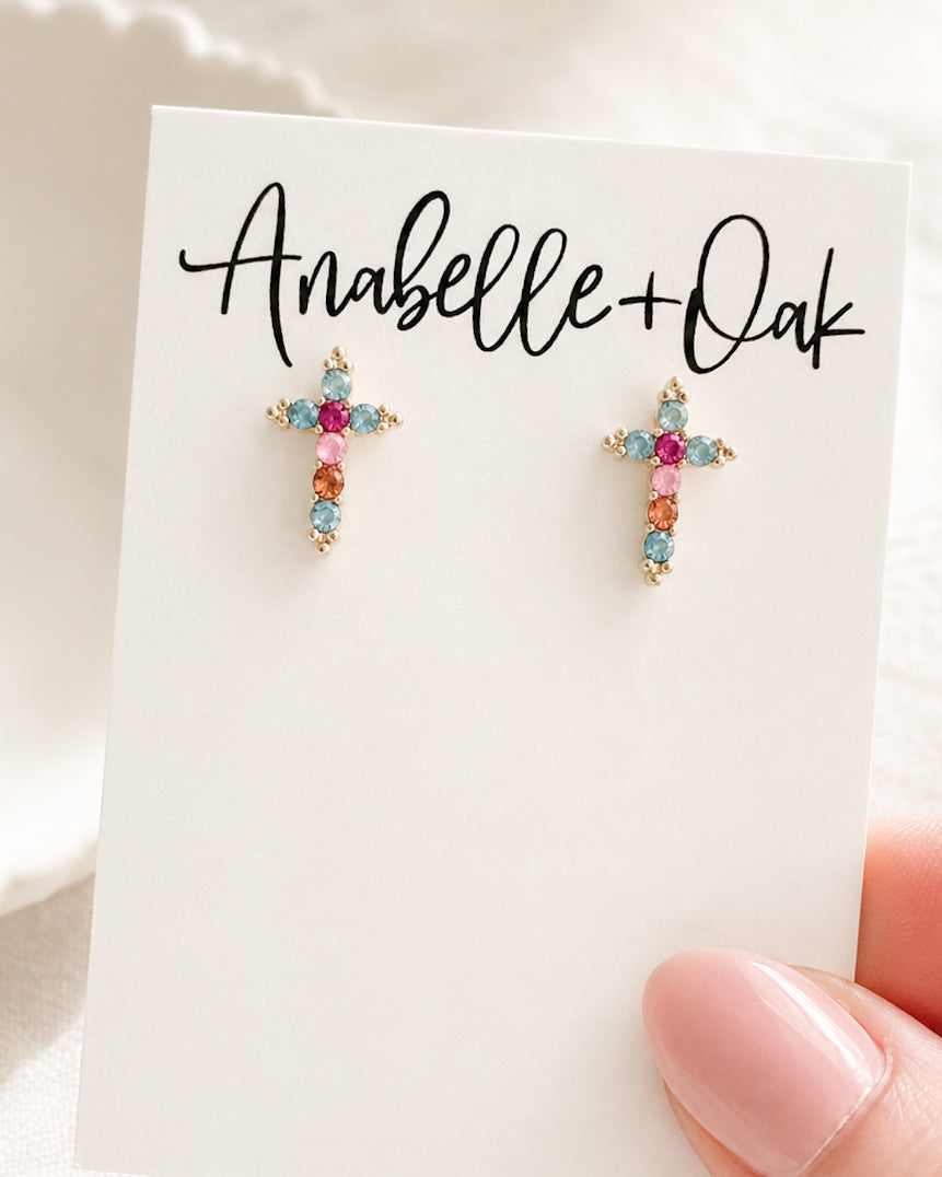 Small colorful cross stud earrings on jewelry card shown for size reference