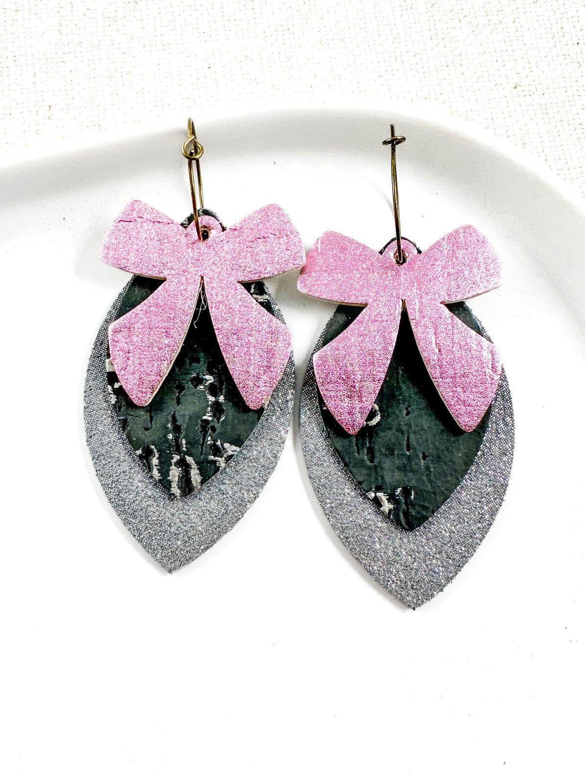 Pink bow and silver layered earrings on white background, handmade holiday earrings from Anabelle+Oak