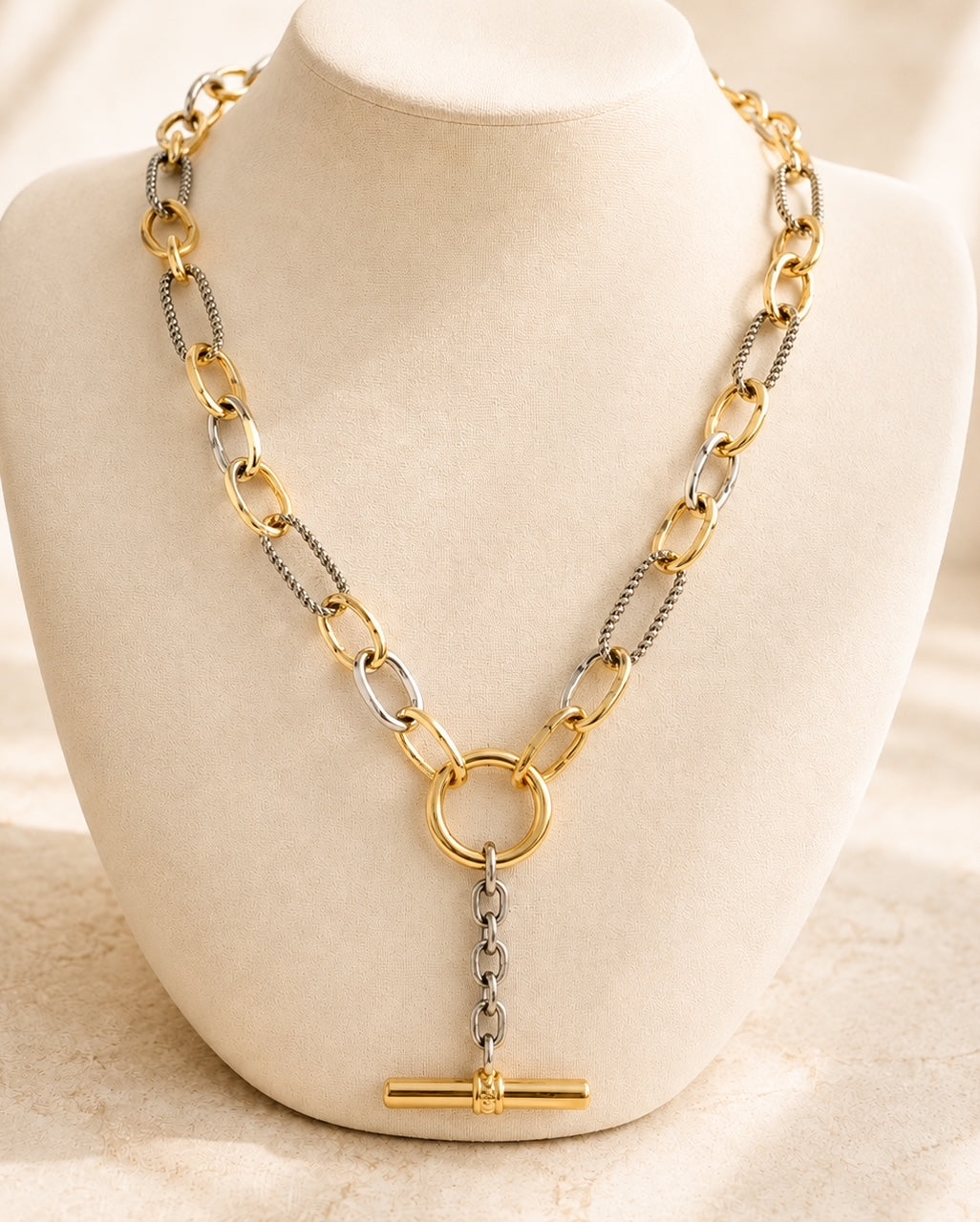 Plot Twist mixed metal necklace displayed on a jewelry bust showing the 18-inch length and Y-drop design