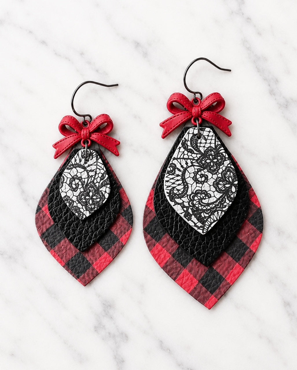 Small and Large Pretty Little Rebel Earrings side by side on white marble, showing the difference in size between the two layered leather statement earrings.