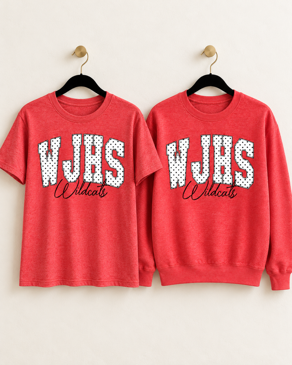 Heather red WJHS Wildcats short-sleeve tee and crewneck sweatshirt displayed together, featuring white varsity letters with black polka dots.