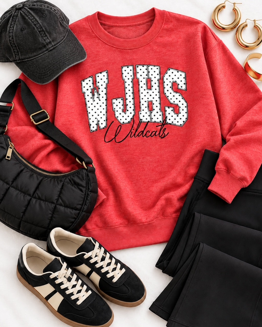Heather red WJHS Wildcats sweatshirt styled with black pants, a black cap, quilted handbag, sneakers, and gold accessories.