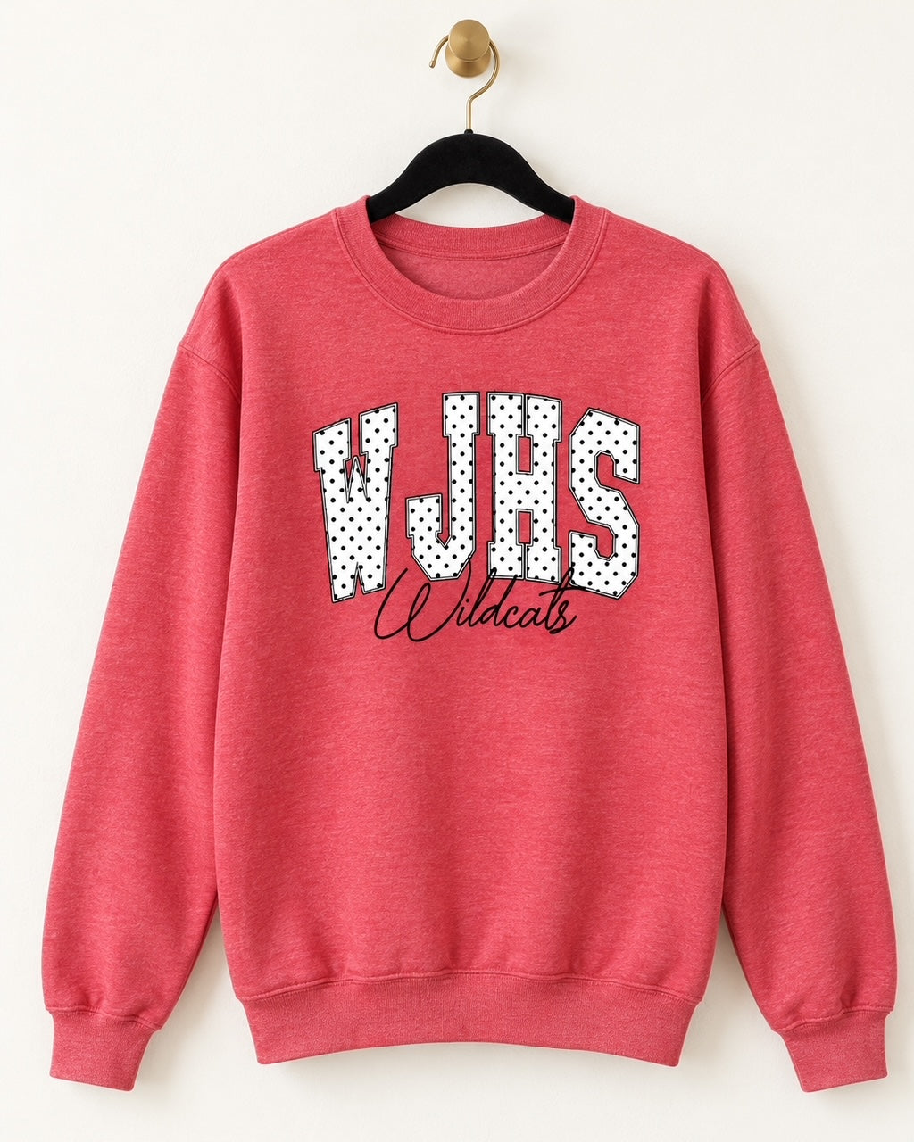 Heather red WJHS Wildcats crewneck sweatshirt with white varsity lettering, black polka dots, and black Wildcats script on a black velvet hanger.
