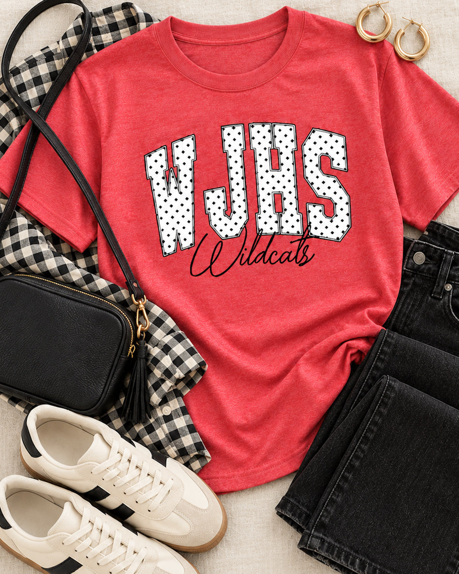 Heather red WJHS Wildcats tee styled with black jeans, gingham shirt, white sneakers, black handbag, and gold hoop earrings.