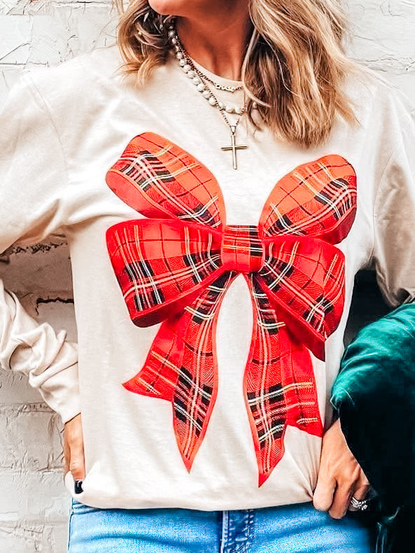 close-up of red plaid bow print on cream tee