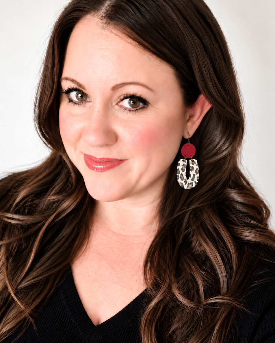 Woman wearing Red Velvet Leopard Earrings with red suede circles and ivory-and-black leopard-print cork drops