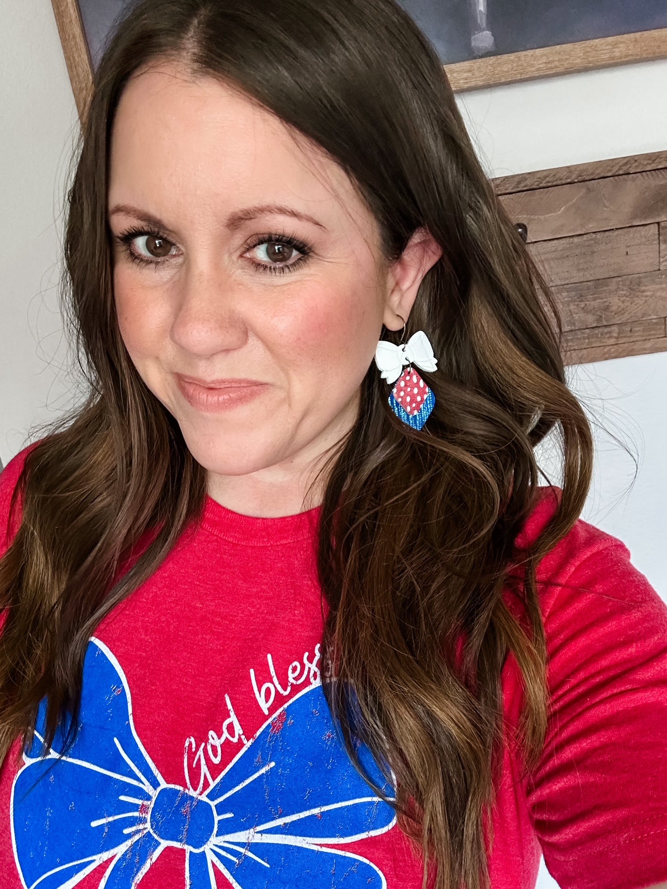 Model wearing Red, White, & Cute Earrings, handmade patriotic bow earrings crafted from cork and genuine leather.