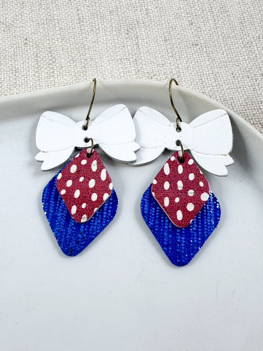 Red, White, & Cute Earrings featuring layered cork and genuine leather with a patriotic bow design and 2-inch drop.