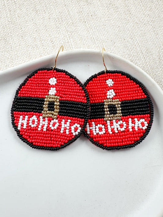 Beaded Santa suit earrings with HO HO HO detail displayed on a white dish.