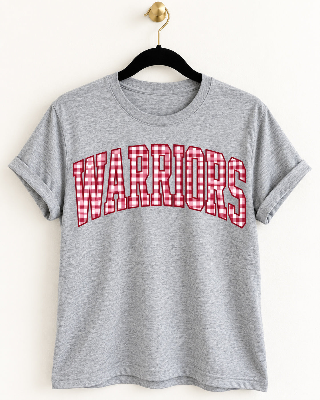 Heather gray tee with oversized WARRIORS lettering in cardinal red and white gingham, hanging on a black velvet hanger.