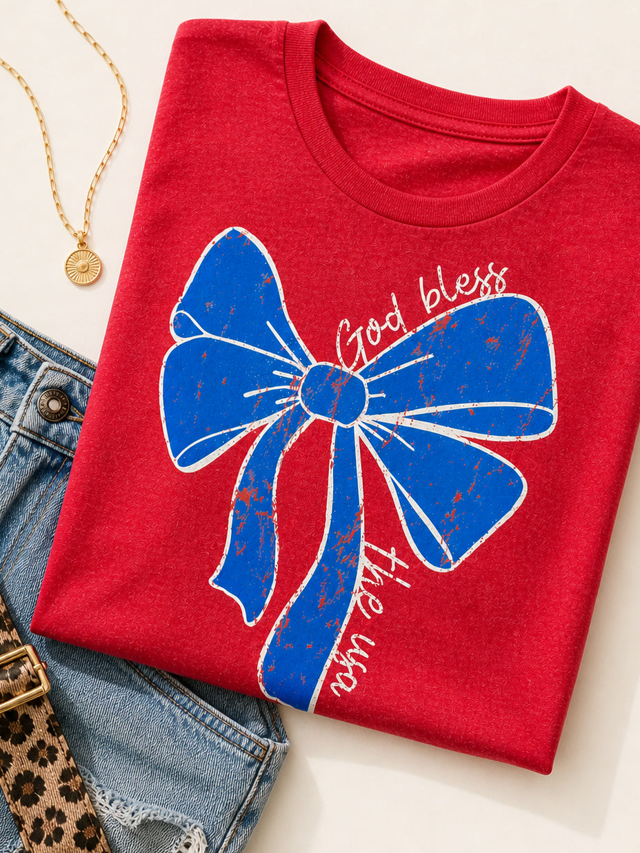 Heather red Small Town USA graphic tee with patriotic bow design styled with denim shorts and accessories.