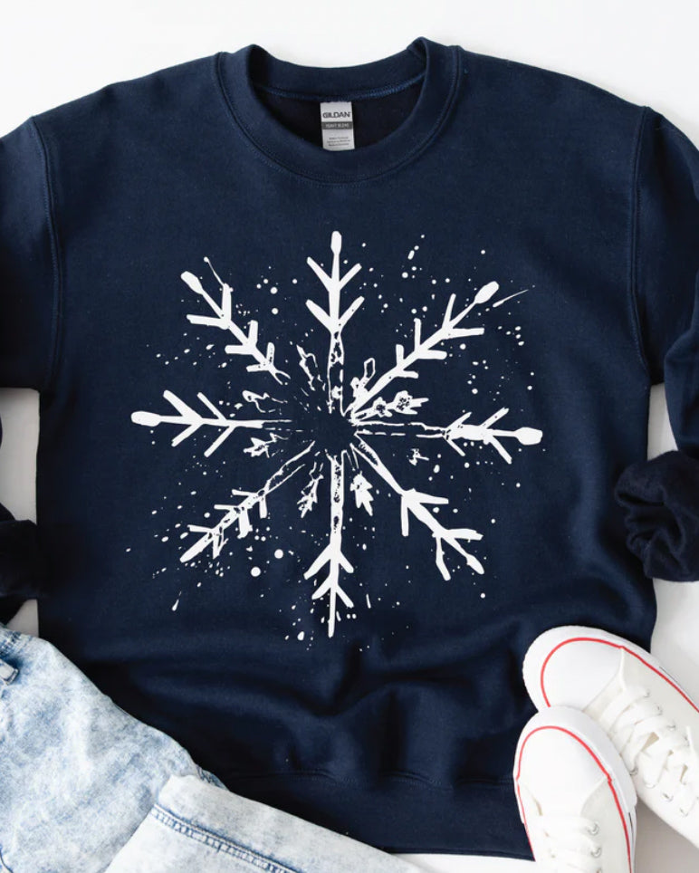 Navy Snowfall Ink sweatshirt featuring a white snowflake graphic, flat lay styled with denim and sneakers