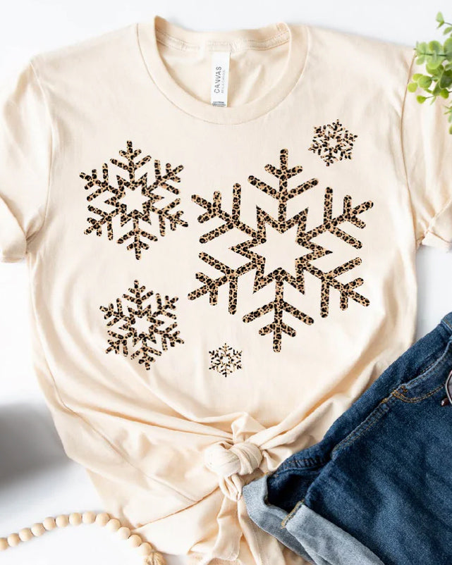 Neutral Snowfall Leopard short sleeve tee featuring a leopard snowflake graphic, styled flat lay with denim, preorder graphic tee