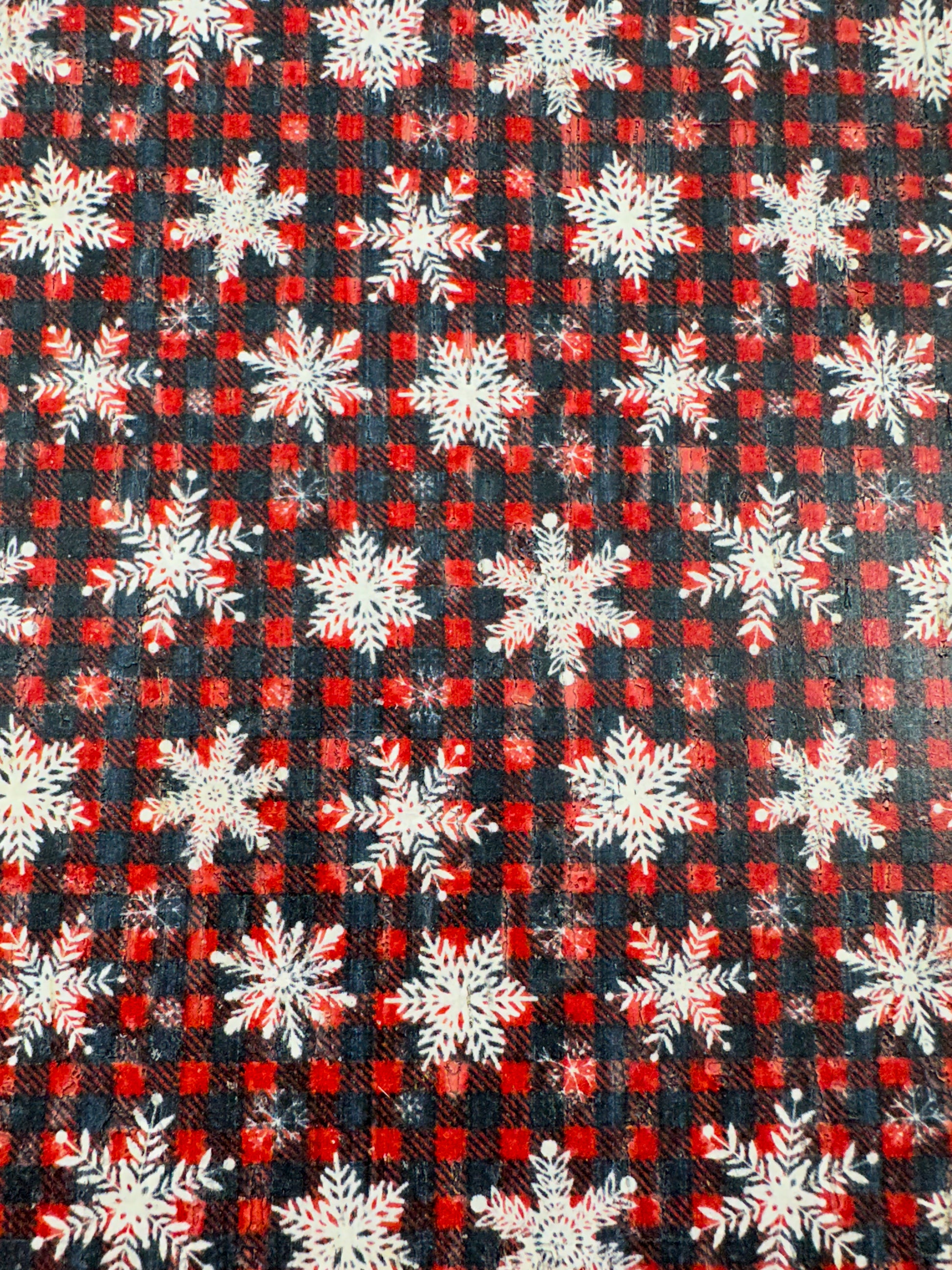 Close-up of the Snowflake & Flannel Cork pattern featuring red and black navy flannel checks with scattered 
white snowflakes.