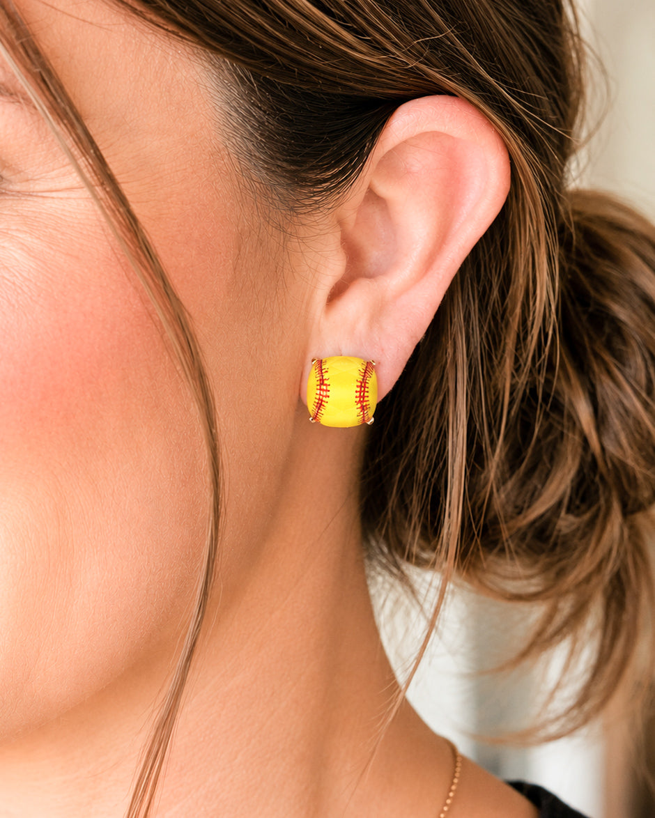 Softball stud earrings shown worn on the ear to demonstrate their lightweight 5/8-inch size.
