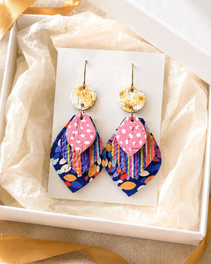 Something Good handmade leather earrings displayed on a jewelry card inside an ivory gift box with gold ribbon