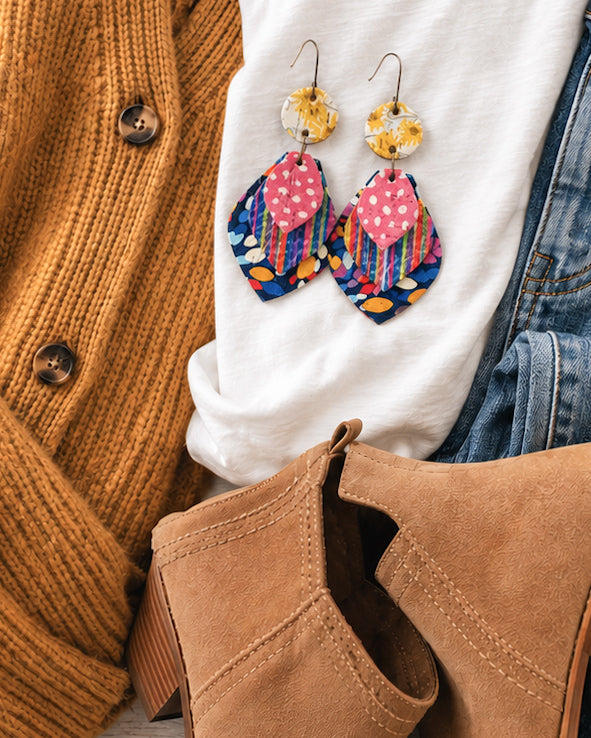 Colorful handmade leather earrings styled with a mustard cardigan, white tee, denim and tan ankle boots for fall