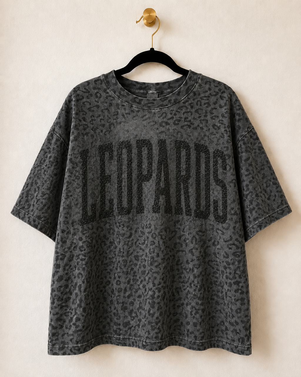Black leopard print LEOPARDS short-sleeve graphic tee displayed on a black hanger.