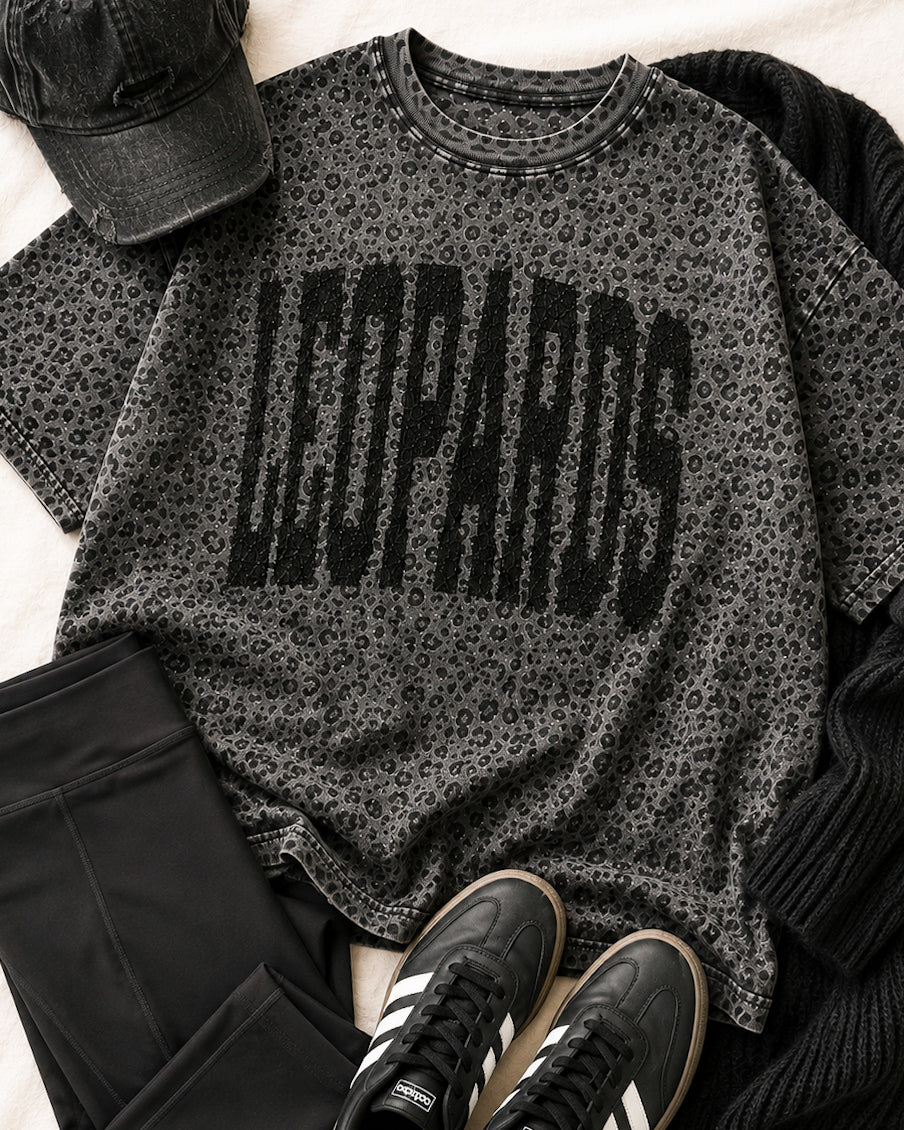 Black leopard print LEOPARDS graphic tee styled with black leggings, black accessories, and sneakers.