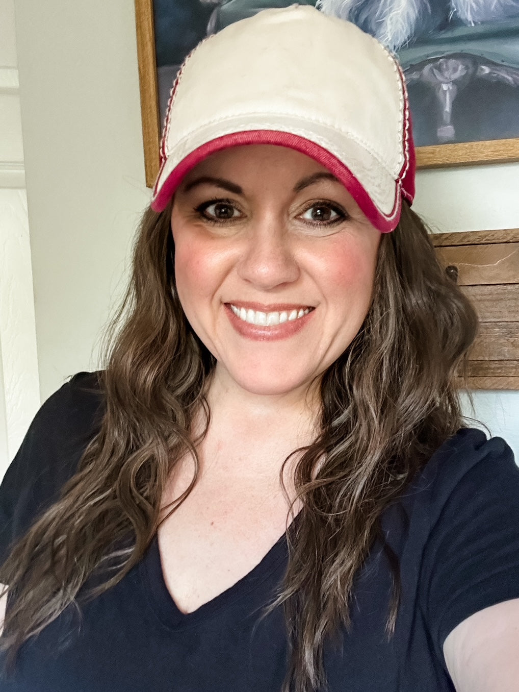 Woman wearing a cardinal red and ivory two tone washed baseball cap with contrast stitching.