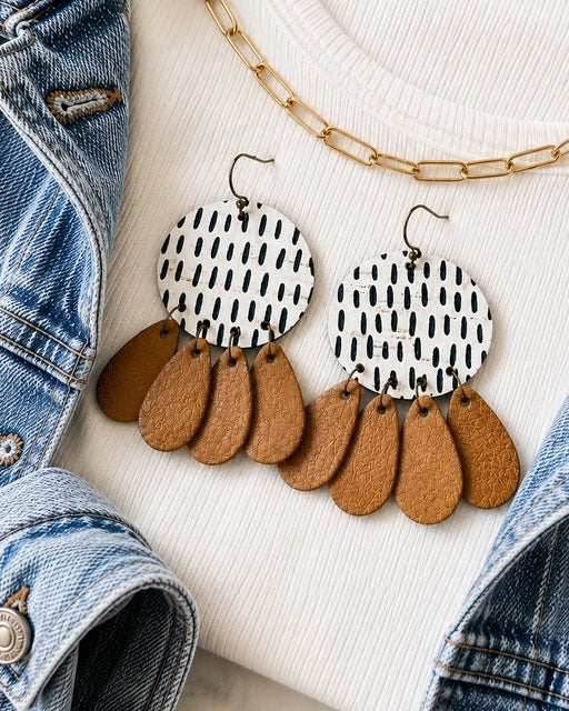 Timeless Terrain handmade cork and genuine leather statement earrings styled with an ivory sweater, denim, camel leather, and gold jewelry.