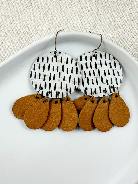 Timeless Terrain handmade cork and leather earrings hanging naturally to show their layered design.