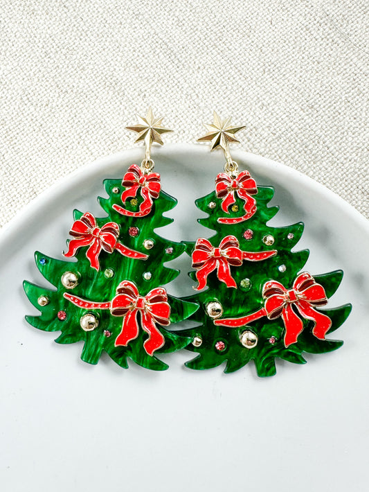 Green Christmas tree earrings with red bows, gold accents, and star stud posts on a white background