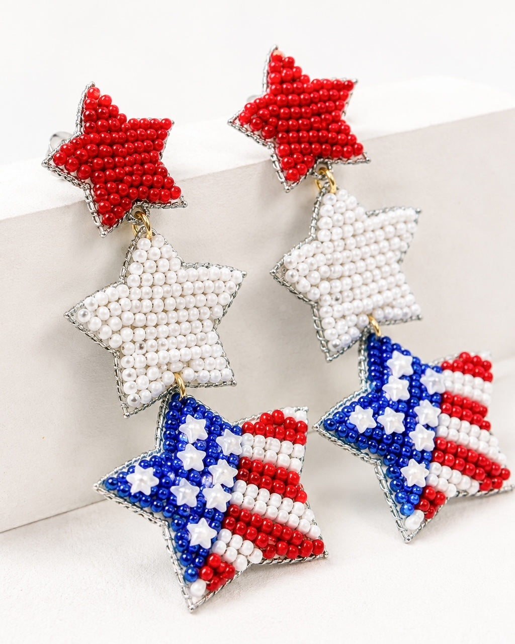 Under the Stars patriotic seed bead earrings displayed on white block showing red white and blue star design