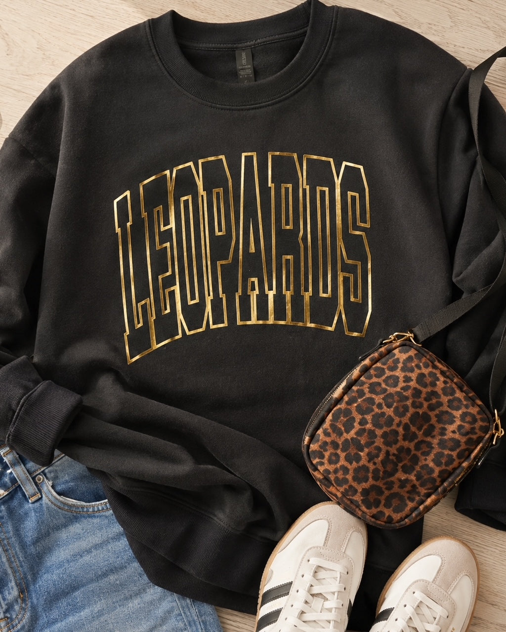 Black Varsity Edit Leopards sweatshirt styled with jeans, sneakers and a leopard-print bag
