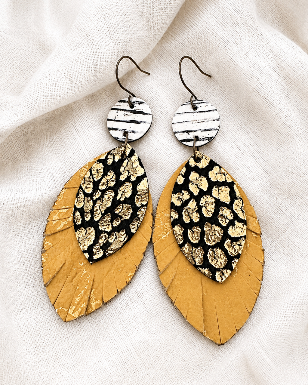 Wild Card Earrings displayed on soft ivory fabric, showing the mixed prints and extra-long design