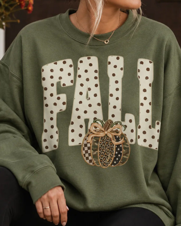 Woman wearing the olive Wild for Fall crewneck sweatshirt with polka-dot lettering and a mixed-print pumpkin.