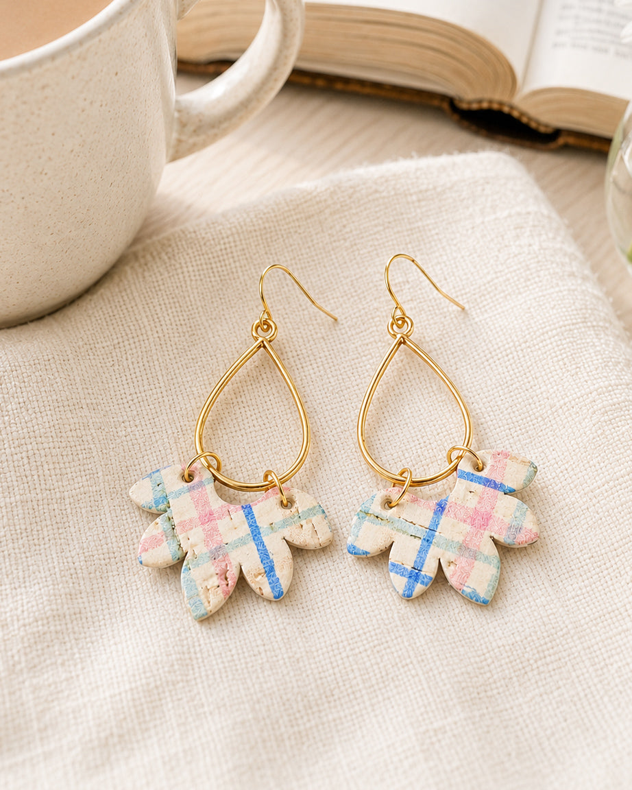 Wildflower Patch handmade cork earrings styled on white linen beside a coffee mug and open book.