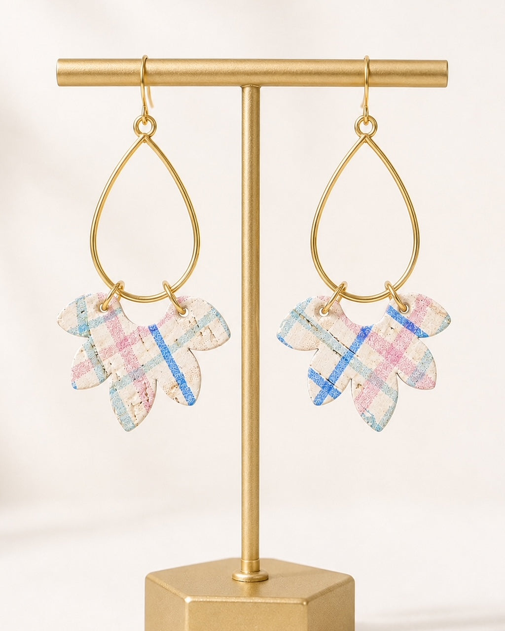Wildflower Patch handmade cork earrings displayed on a matte gold T-stand.