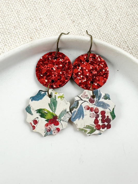 Winterberry Drop Earrings with red glitter circles and winter berry cork charms displayed on a white dish.